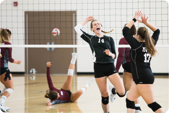 Students celebrating during volleyball game showing motivation and achievement